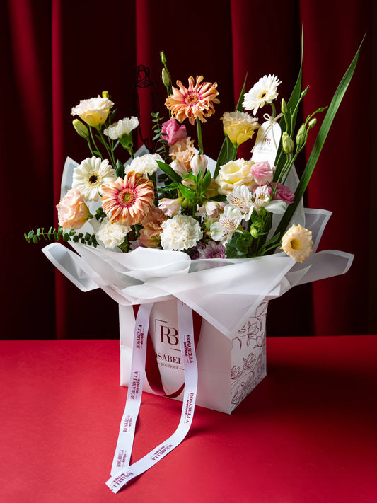 Milestone Blooms Handbag Arrangement with vibrant flowers in an elegant handbag, crafted as graduation flowers, available with delivery to Dubai, Sharjah, and Muwaileh.