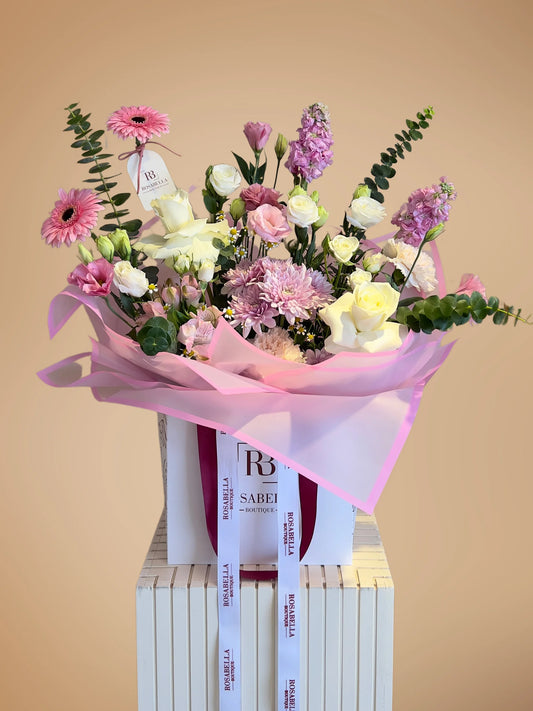 Serenade in Bloom Handbag Arrangement with soft pink, purple, and white flowers in a chic handbag, available at a flower boutique with delivery to Dubai, Sharjah, and Muwaileh.