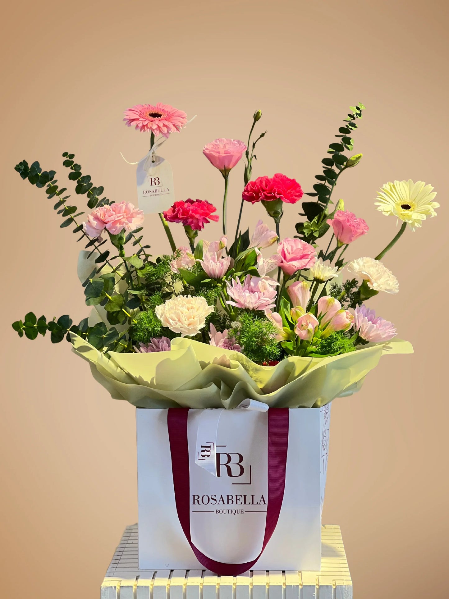 Charming Glimmer Handbag Arrangement with soft pink, white, and green flowers, crafted by a flower shop near me with delivery to Dubai, Sharjah, and Muwaileh.