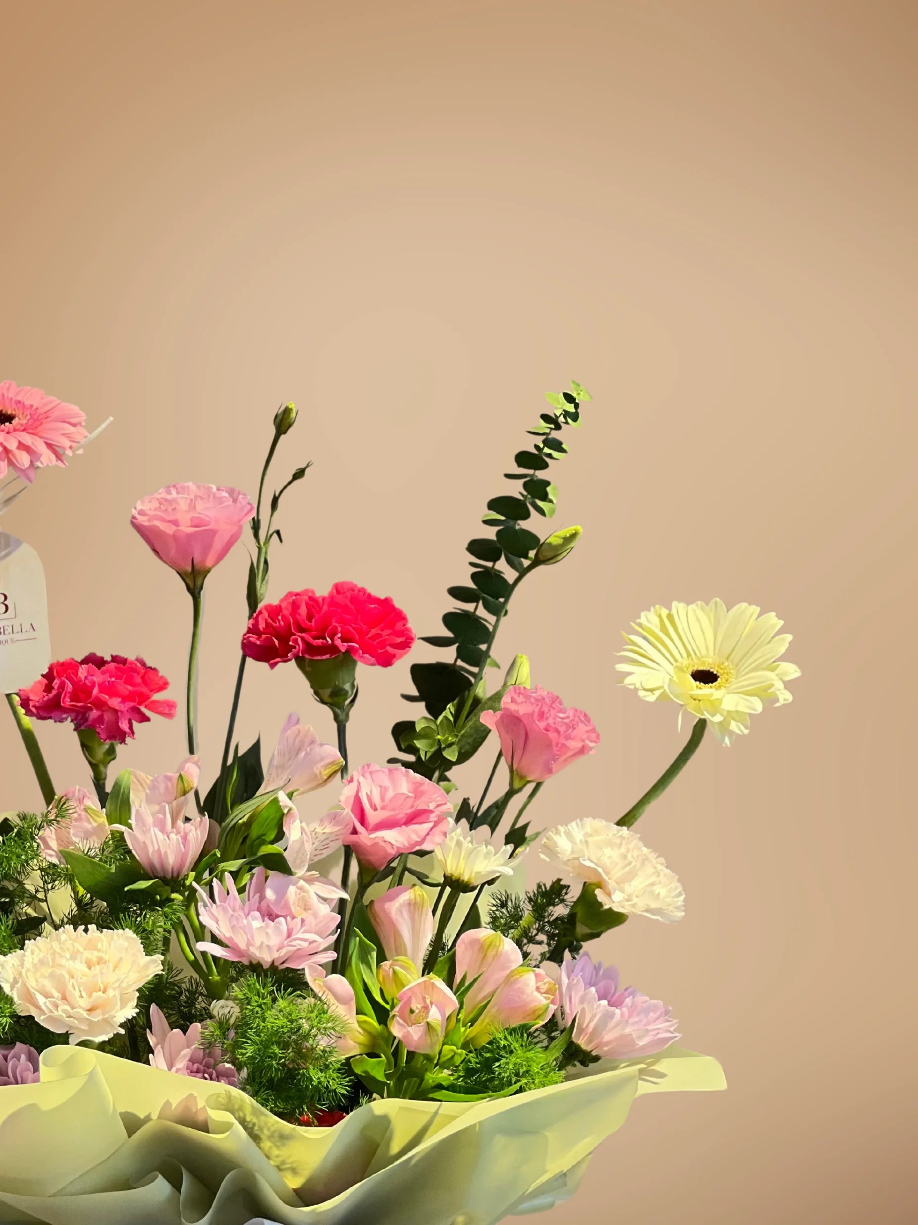 Charming Glimmer Handbag Arrangement with soft pink, white, and green flowers, crafted by a flower shop near me with delivery to Dubai, Sharjah, and Muwaileh.