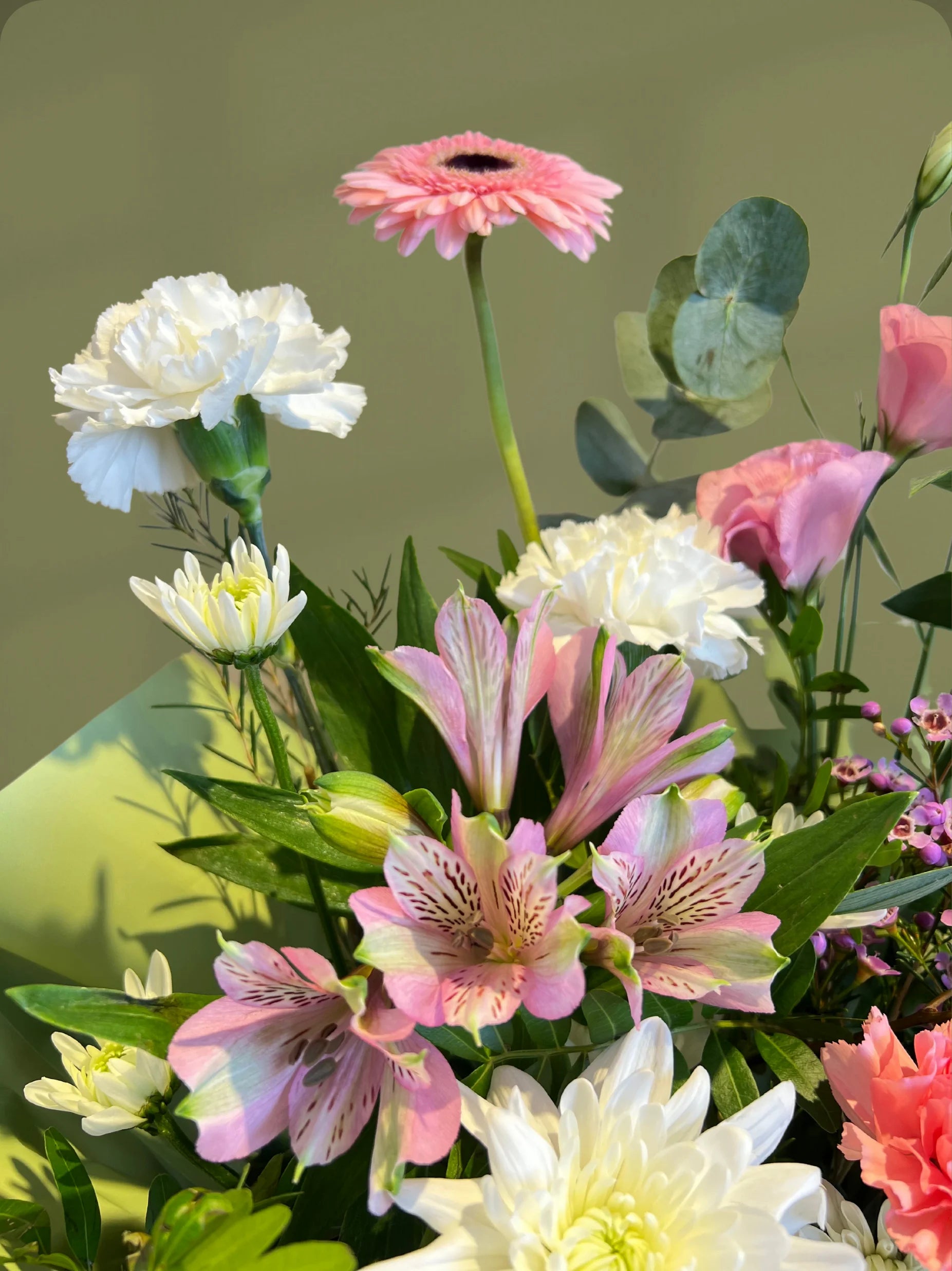 Cotton Candy Handbag Arrangement with pink, white, and green flowers, styled in a handbag with soft pink wrapping, available with flower delivery to Dubai and Sharjah.