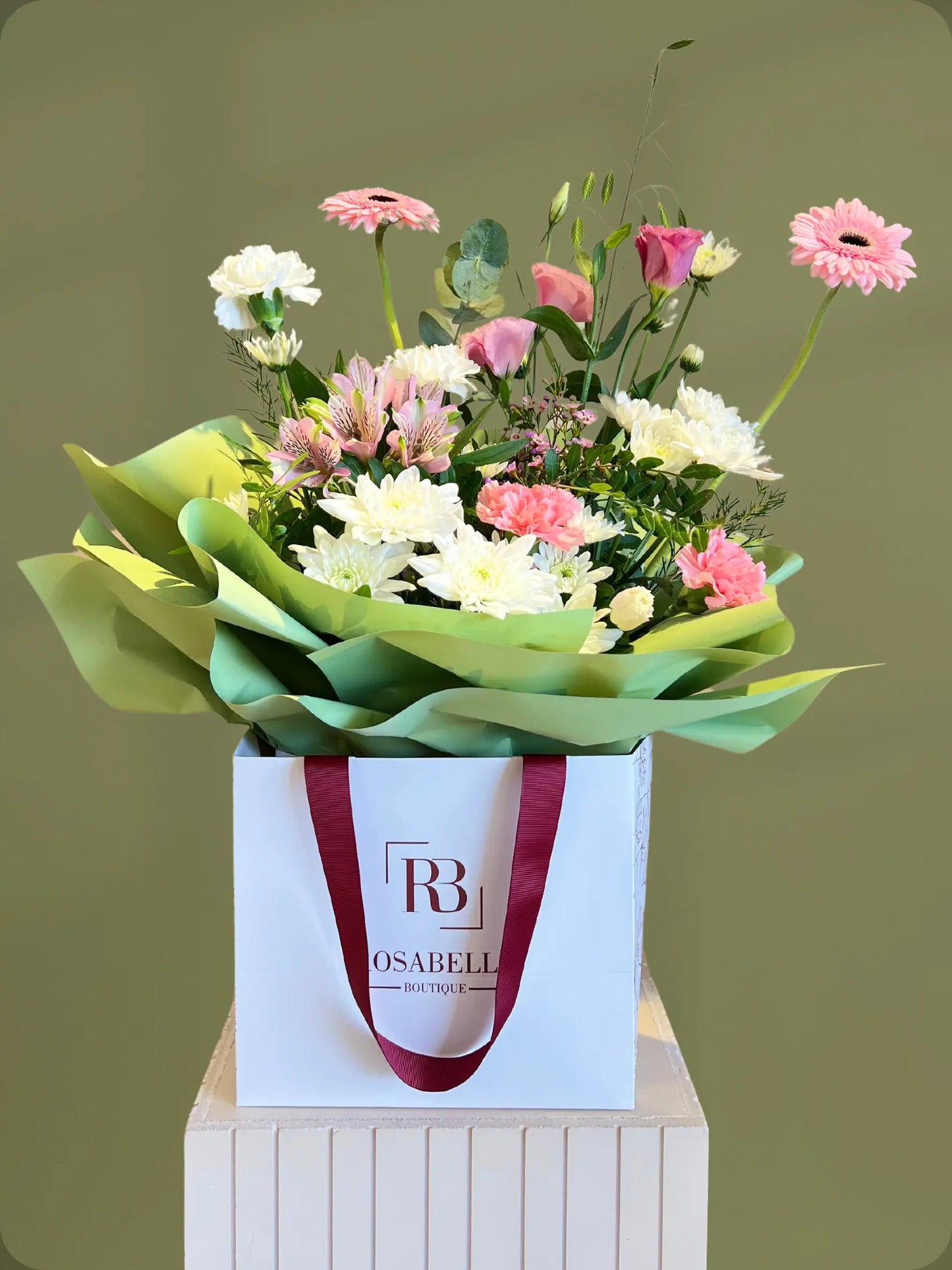 Cotton Candy Handbag Arrangement with pink, white, and green flowers, styled in a handbag with soft pink wrapping, available with flower delivery to Dubai and Sharjah.