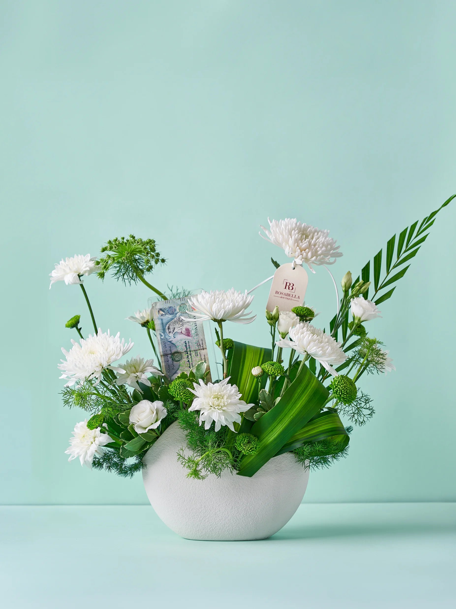 Ethereal Greens Vase Arrangement with white flowers and lush greenery in a ceramic vase, available at a flower boutique with delivery to Dubai, Sharjah, and Muwaileh.