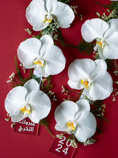 Graduation Garland Arrangement with elegant orchids in a necklace-style garland, crafted by a flower boutique with delivery to Dubai, Sharjah, and Muwaileh.