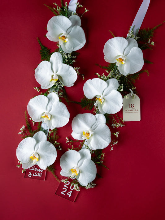 Graduation Garland Arrangement with elegant orchids in a necklace-style garland, crafted by a flower boutique with delivery to Dubai, Sharjah, and Muwaileh.