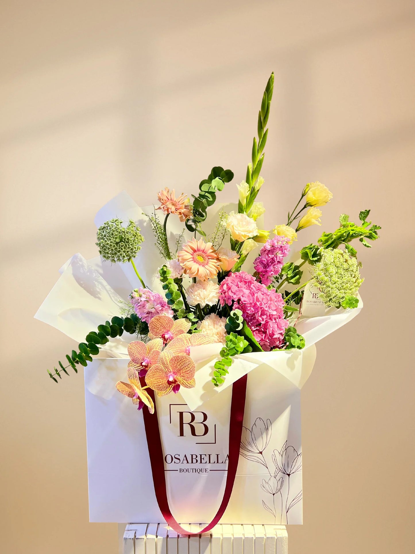 Orchid Splendor Handbag Arrangement with vibrant Gerberas and exquisite orchids in a stylish handbag, available as special flowers with delivery to Dubai, Sharjah, and Muwaileh.