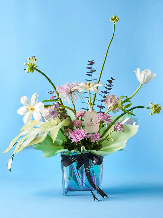 Tulip Bliss Vase Arrangement with soft peach blooms and lush greenery in a clear vase with pebble accents, available at a flower shop near me with delivery to Dubai and Sharjah.