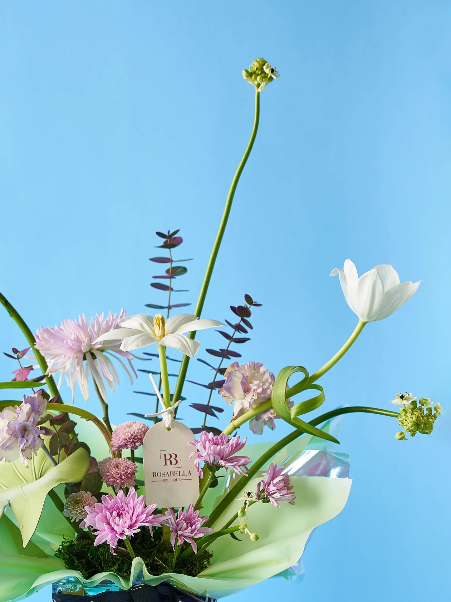 Tulip Bliss Vase Arrangement with soft peach blooms and lush greenery in a clear vase with pebble accents, available at a flower shop near me with delivery to Dubai and Sharjah.