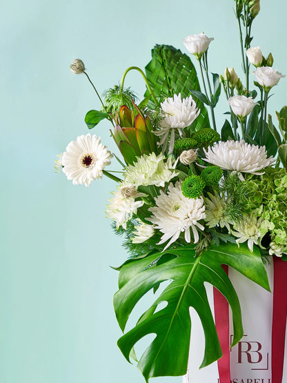 Lily Grace Handbag Arrangement with Calla lilies, lush greenery, and white blooms in a chic handbag, available as special flowers with delivery to Dubai, Sharjah, and Muwaileh.